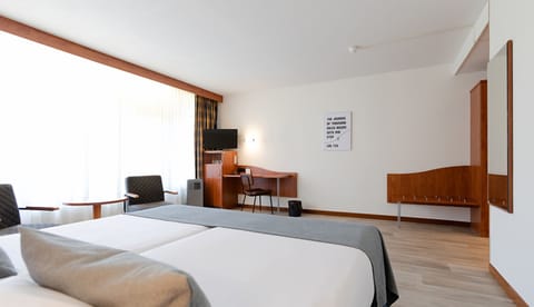 Recharge in a spacious room with desk and TV corner.