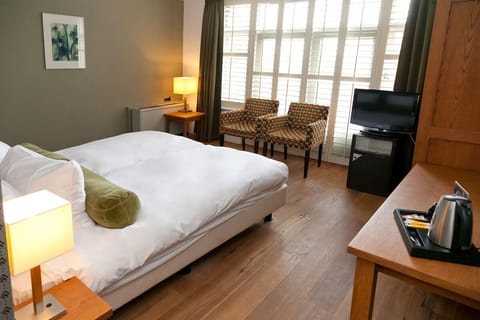 Sip tea and relax beside the bed with sunny window views.