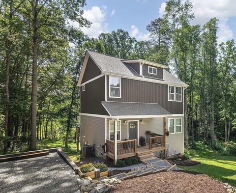 Tucked among the trees, this thoughtfully designed retreat blends modern craftsmanship with a peaceful wooded setting. A welcoming front porch sets the tone for a private, elevated escape just moments from everything you came to explore.