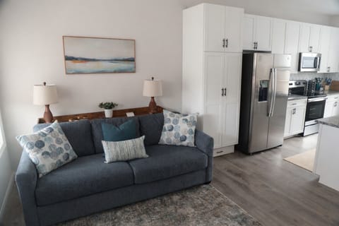 An effortless blend of style and function, this entry living space flows seamlessly into the kitchen. Settle in by the electric fireplace, unwind on the sofa, and ease into the rhythm of your retreat.