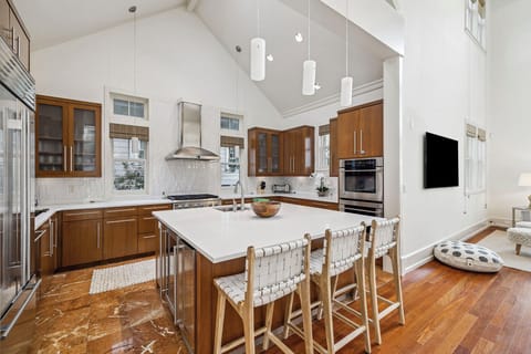 Your gourmet kitchen features soaring ceilings, sleek pendant lights, and a spacious island where you'll love preparing meals and gathering.