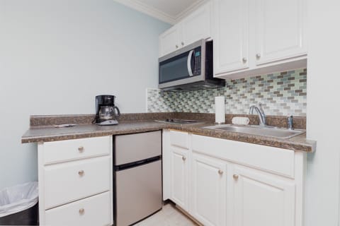 Convenient kitchenette with microwave, mini fridge, coffee maker, and sink for easy meals