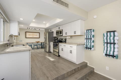 Bright and welcoming dining space with a wooden table and blue chairs. Unique wall art adds character and charm to every meal.