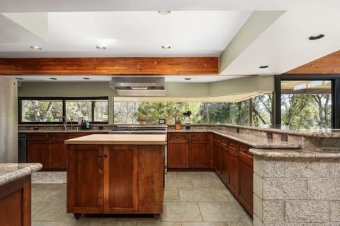Large fully stocked chef’s kitchen kitchen which w/ fridge, dishwasher, and water filtration system