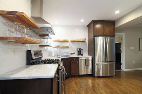 Bright kitchen with full-height subway tile, stainless steel appliances, gas range with hood, and a built-in breakfast nook. Fully stocked with cookware, utensils, and a Ninja dual coffee maker for pods or ground coffee.