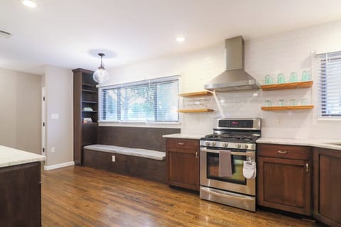Bright kitchen with full-height subway tile, stainless steel appliances, gas range with hood, and a built-in breakfast nook. Fully stocked with cookware, utensils, and a Ninja dual coffee maker for pods or ground coffee.