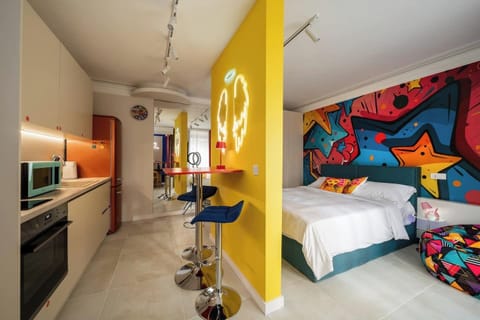 Your pop-art escape awaits — bold graffiti murals and glowing neon angel wings set the tone the moment you walk in