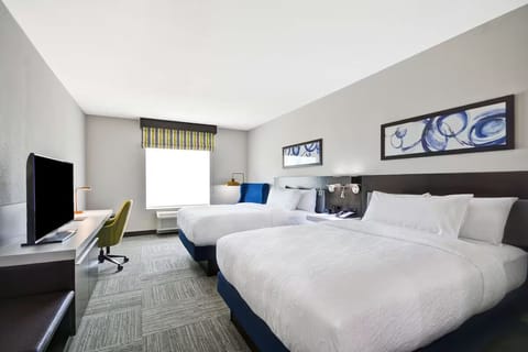 Unwind in bright double-queen comfort with TV and work desk.