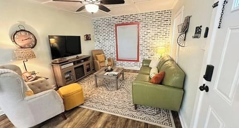 Cozy living room with smart TV, brick accent wall, and plush seating