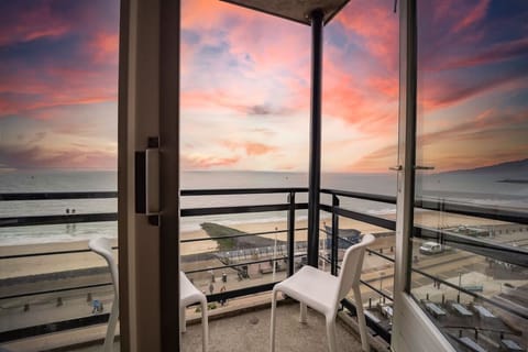 Sip wine on the balcony as sunsets glow over sea.
