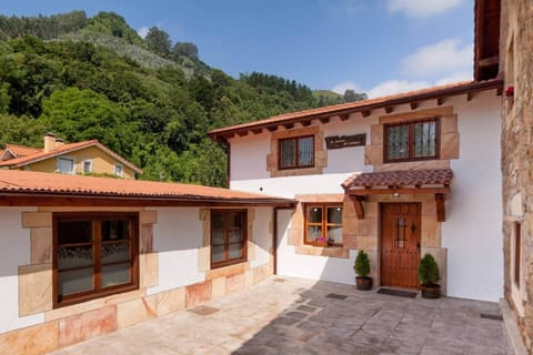 Casa de piedra y madera con porche, sobre el valle