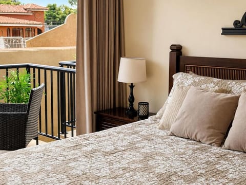 Cozy bedroom with soft bedding and a private balcony seating area.
