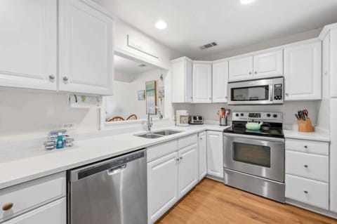 Modern, fully equipped kitchen with stainless appliances and stacked washer/dryer