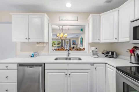Modern, fully equipped kitchen with stainless appliances and stacked washer/dryer