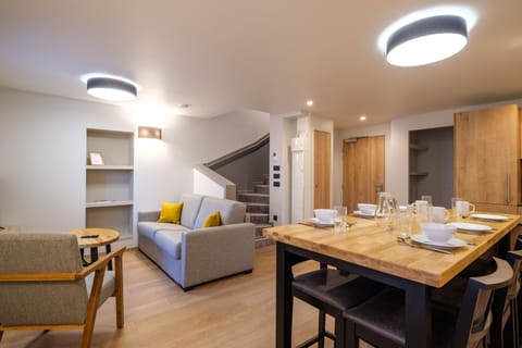 The inviting living area features comfortable seating and a dining table, creating a welcoming space for relaxing and shared meals.