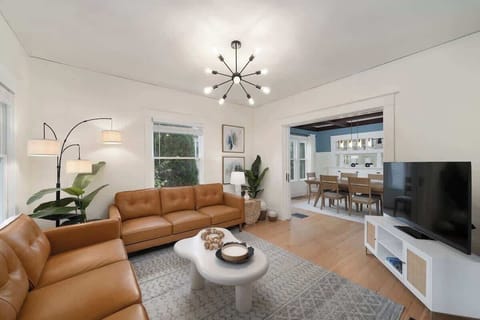 Cozy living room with a spacious brown couch and Smart TV, perfect for relaxation and entertainment.