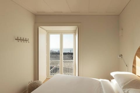 Unwind in a bright, minimalist room with balcony doors.