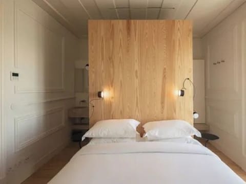 Sink into the serene bed framed by warm wood textures.