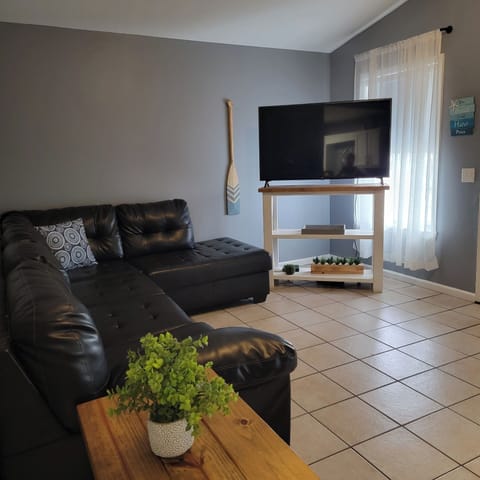 Comfortable living area with leather sofa, smart TV, and coffee table