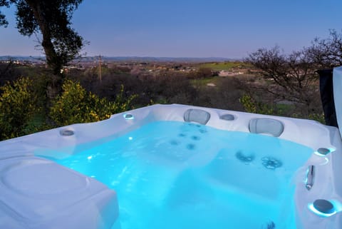 This illuminated hot tub offers a glowing retreat at twilight, perfectly positioned to take in the sprawling valley views and rolling hills.