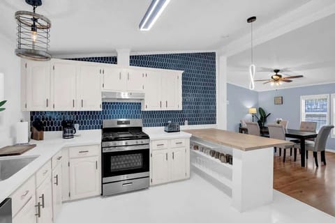 Propane Gas Range, Quartz Countertops, Farmstyle Sink, Matte Black Fixtures and a beautiful tile backsplash on the first floor kitchen.