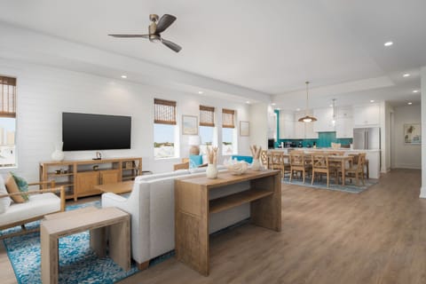 A spacious living area highlighted by large windows, contemporary furnishings, and a harmonious coastal color palette.