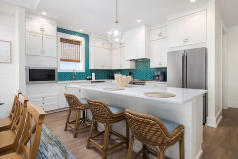 This coastal-inspired kitchen features vibrant teal backsplash and a spacious island perfect for gatherings.