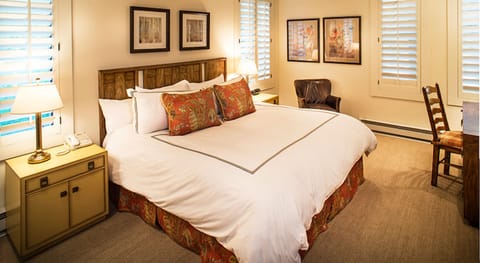 Unwind in a plush king bed with soft, lamplit comfort.