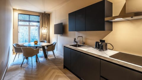 De keuken beschikt over een moderne inductiekookplaat voor veilig en efficiënt koken, en gasten hebben ook toegang tot een rustige gedeelde tuin—perfect om te ontspannen na het verkennen van de stad.