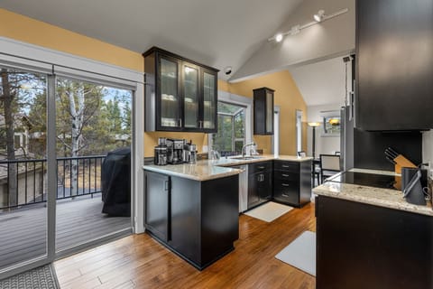 Your fully-equipped kitchen awaits with granite countertops, stainless appliances, and sunny balcony access for morning coffee with treetop views.
