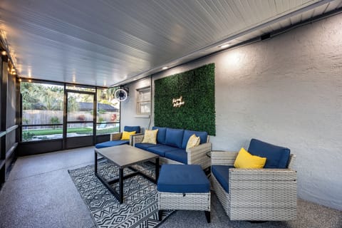 Relax in your stylish covered patio with comfortable seating, surrounded by lush garden views and modern design touches.