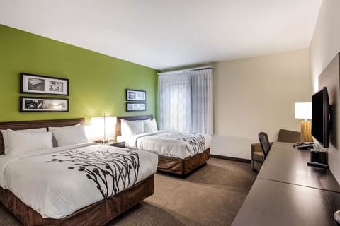 Unwind in a bright double-queen room with cozy seating.