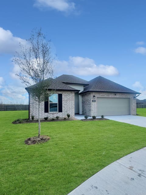 Modern brick exterior and landscaped front yard welcome you to Lucky Lakes.