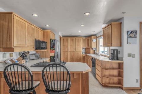 Your spacious kitchen features warm wood cabinets, modern appliances, and a breakfast bar where you can enjoy morning coffee.