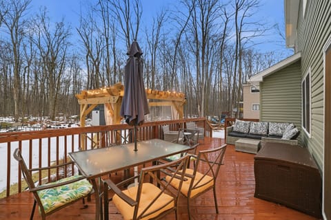 Deck in the back of the house with seating, table with umbrella
