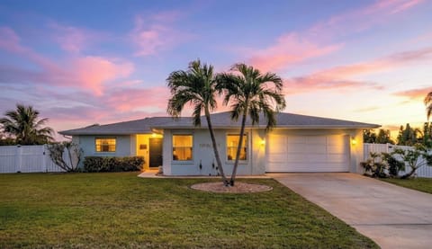 Tropical paradise awaits at this stunning property, framed by swaying palms and painted in sunset hues.