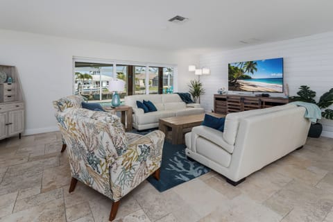 Sink into plush white sofas and watch tropical beach scenes on the large TV while natural light streams through waterfront windows.