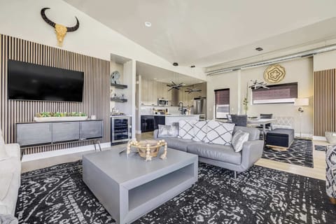 This sophisticated social center is a masterclass in intentional design, featuring plush designer seating and a minimalist coffee table. A floor-to-ceiling wood slat feature wall provides a warm, architectural backdrop for the home.