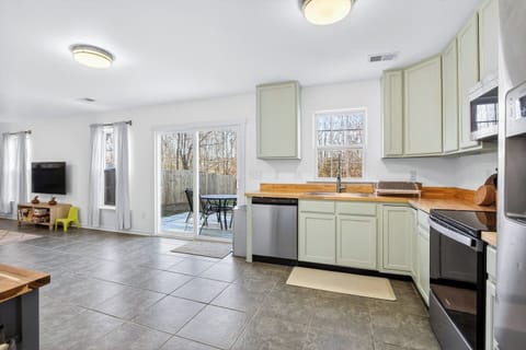 Bright open space connecting the kitchen, living room, and outdoor patio.