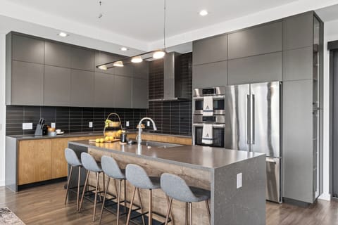 Sleek chef’s kitchen with a spacious island, bar seating, and premium stainless steel appliances.