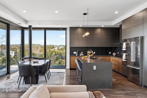 Sleek chef’s kitchen and scenic dining area with floor-to-ceiling hill views.