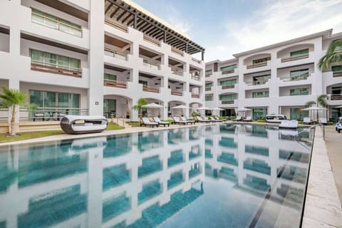Drift in the tranquil courtyard pool surrounded by sleek balconies.