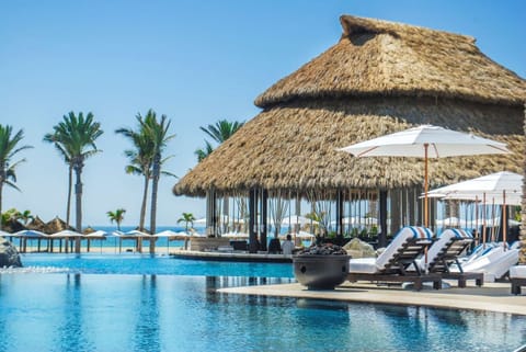 Sip poolside cocktails and lounge under breezy thatched shade.