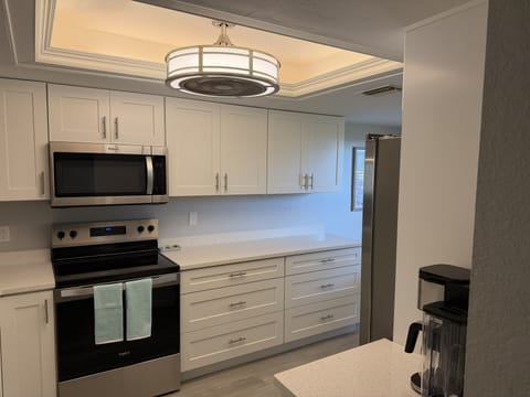 Sparkling clean and spacious white countertops with plenty of cabinet storage.
