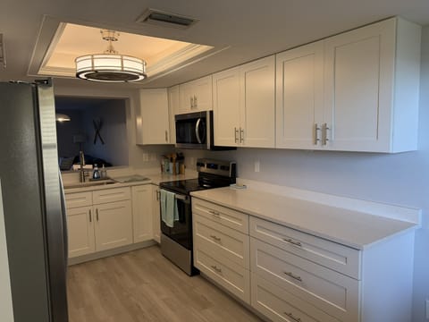 Kitchen view with bright and modern fandelier for staying cool while cooking.