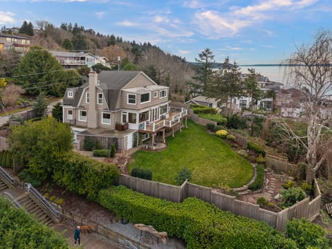 Aerial view of the home with expansive private backyard and sweeping water views