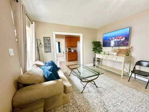 This open-concept living room features two comfortable sitting areas, a central TV, and beautiful lake views — the perfect space to relax and gather.