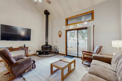Living room with wood burning stove, flat screen tv, and patio access