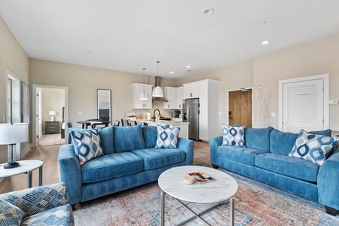 Open-concept living and dining area with modern kitchen, stylish furnishings, and a cozy lounge space.