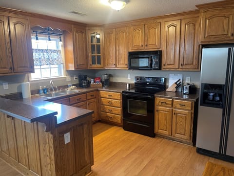 Kitchen with oven range, microwave and refrigerator.